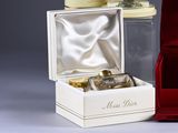 une boîte rouge avec un flacon de parfum à côté