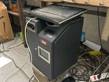 a computer on top of a black box in a messy room