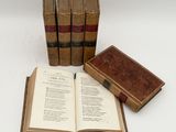 three old books sitting on top of each other on a table