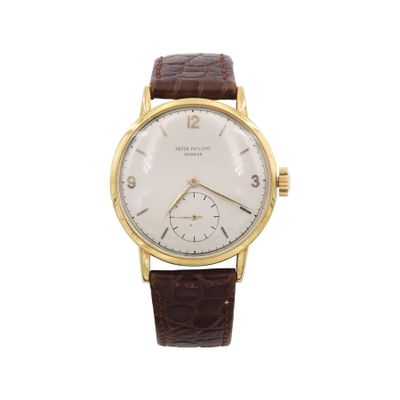 gros plan d'une montre sur fond blanc avec un bracelet marron