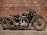 a old motorcycle that is parked in front of a brick wall