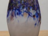 a blue and white vase sitting on a wooden table