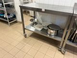 une table en acier inoxydable sur laquelle sont posés des casseroles et des poêles