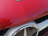 a close up of a mercedes emblem on the front of a red car