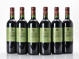 six bouteilles de vin sont alignées sur une surface blanche