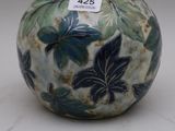 un vase bleu et blanc orné de feuilles vertes