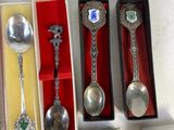 several silver spoons and spoon spoons in boxes on a table