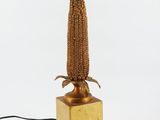 a gold colored lamp with a wooden base and a rope wrapped around the base