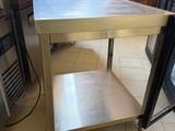 a stainless steel table in the middle of a kitchen