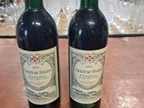 deux bouteilles de vin rouge posées sur une table en bois