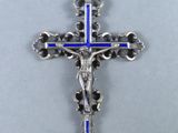 une croix en argent surmontée d'une croix bleue