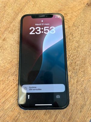 un gros plan d'un téléphone portable posé sur une table en bois