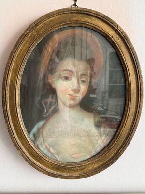 un tableau représentant une femme coiffée d'un chapeau, accroché au mur