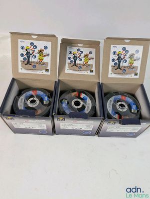 four spools of spools of various sizes and colors in a box