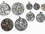plusieurs médailles d'argent de différentes tailles et formes sur fond blanc