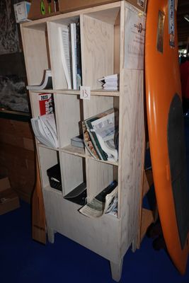 une planche de surf orange appuyée contre une bibliothèque