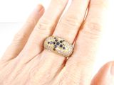 an image of a woman ' s hand holding a ring with black and white diamonds