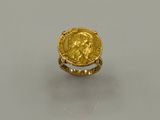 Gros plan sur une bague en or ornée d'une pièce de monnaie