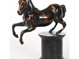 statue en bronze représentant un cheval sur un socle, sur fond blanc