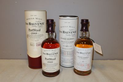 trois bouteilles de whisky posées sur une table à côté d'un bidon