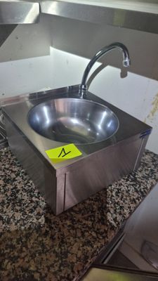 a stainless steel sink with a yellow sticker on it