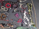 many different types of necklaces and bracelets on the table