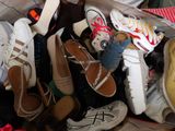 many pairs of shoes in a bag on the floor