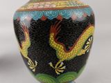 a vase with a dragon on it sitting on a table