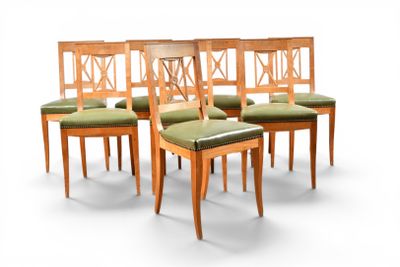 quatre chaises en bois avec des assises rembourrées vertes, posées sur une surface blanche