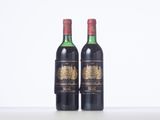 two bottles of wine sitting on top of a white table