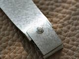 a small metal object on a leather surface