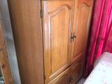une armoire en bois et un miroir dans un coin de la pièce