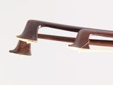 a wooden instrument that is being held up by a pair of scissors