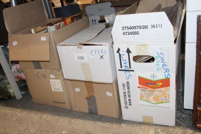 a pile of boxes sitting on the ground next to a refrigerator