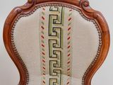 an old chair with a striped seat and a wooden frame