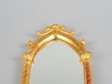 a mirror with a gold frame on the wall