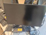 un écran d'ordinateur posé sur un bureau, à côté d'un clavier et d'une souris
