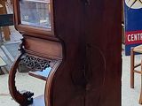 a piano in the middle of a room with a red wall
