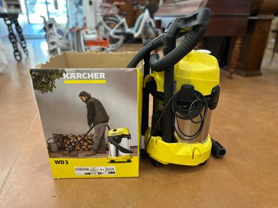 a yellow vacuum cleaner sitting on top of a wooden floor next to a box of wood