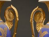 pair of blue and gold vases sitting on top of a table