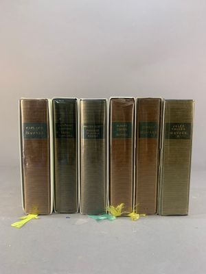 quatre livres sont alignés sur une surface blanche