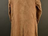 a brown coat on a mannequin stand against a black background