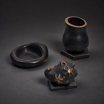 trois pièces de poterie noire posées sur une table