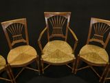 four wooden chairs are lined up against a black background
