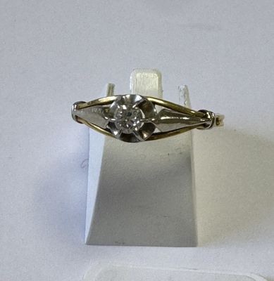 une bague en argent sertie d'un diamant, posée sur un fond blanc