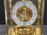 a gold clock that is sitting on a table