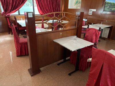des tables et des chaises dans un restaurant, ornées de rideaux rouges