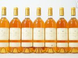 six bouteilles de vin sont alignées sur une table