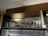 a shelf with wine glasses and bottles on it