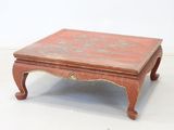 a small red table with a floral design on it